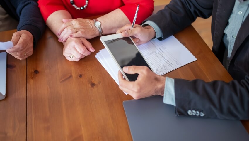 image of hands, one holding ipad and pen