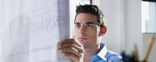 architect reading blueprint in office