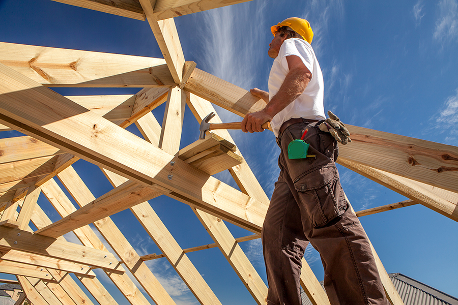 roofer worker builder working on roof structure at construction site