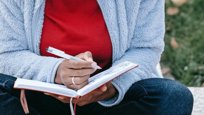 business-planning-for-new-year Woman writing in a journal