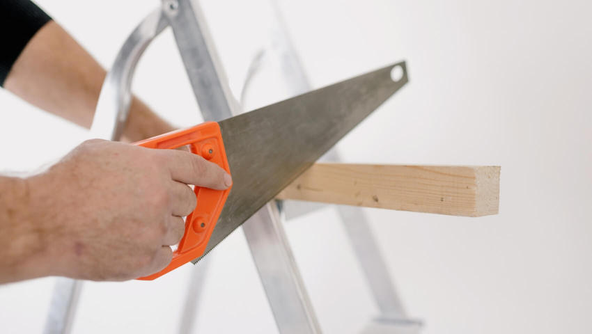 independent-contractor-insurance Hands sawing a piece of wood