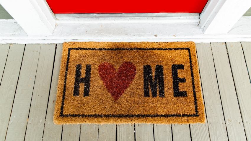 Welcome mat that says home with red heart