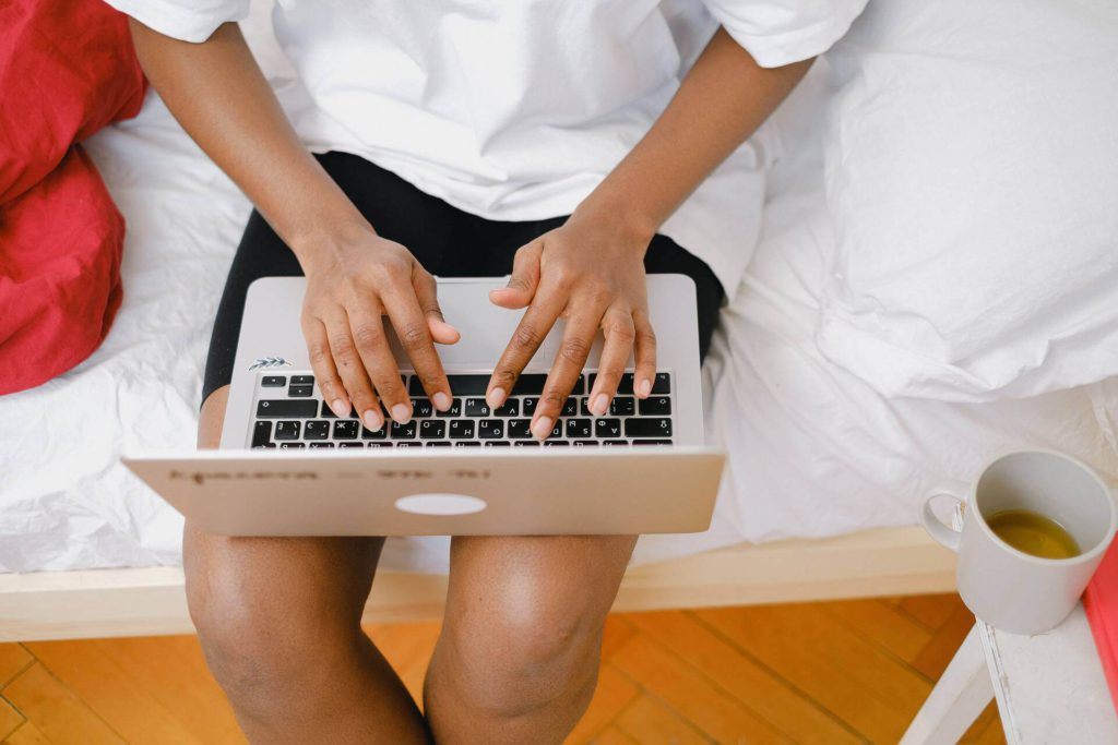 laptop on woman's lap, hands typing